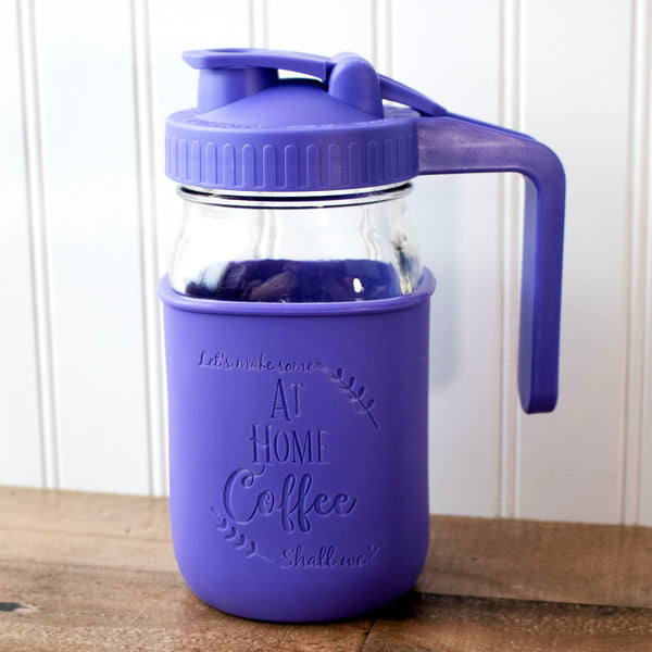 Purple insulated coffee cup with handle on a wooden surface