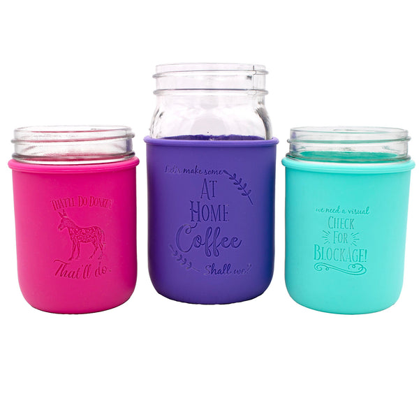 Three mason jar-style cups with colorful silicone sleeves on a white background
