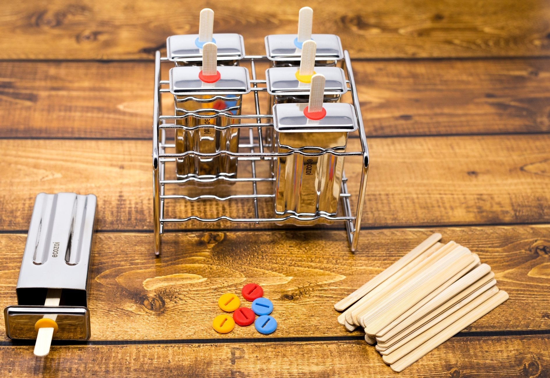 Popsicle mold with colorful sticks on a wooden surface