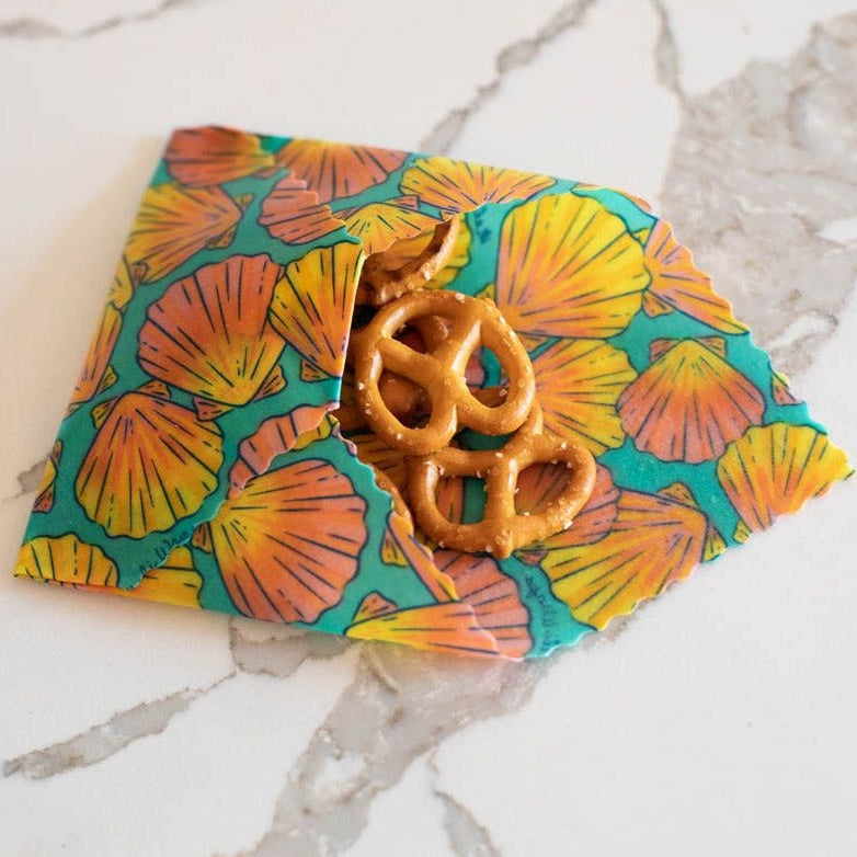 Colorful reusable snack bag with pretzels on a marble surface