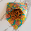Colorful floral-patterned bag with pretzels on a marble surface