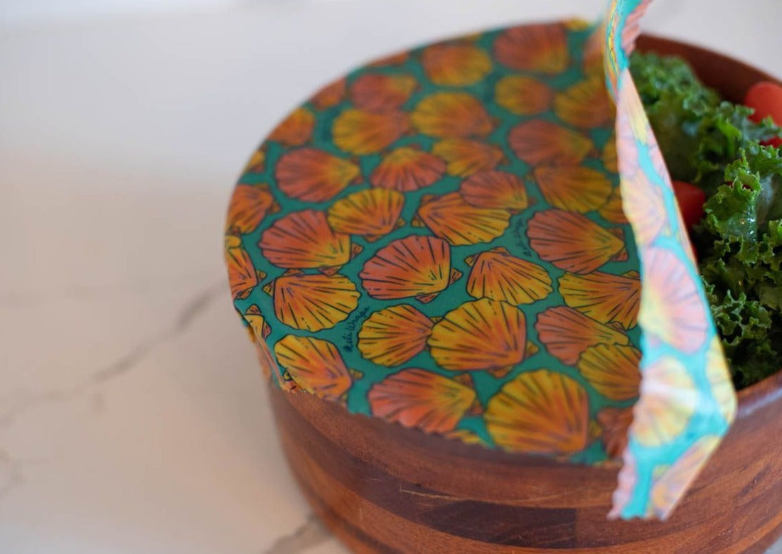 Wooden container with colorful shell-patterned lid on a white surface