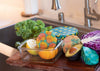 Colorful reusable food wraps on fruits and vegetables in a kitchen setting