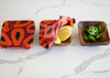 Three decorative plates with colorful patterns on a marble surface