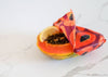 Half-cut papaya with a colorful butterfly on a white marble surface