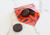 OREO cookies spilling out of a colorful fabric bag on a white surface