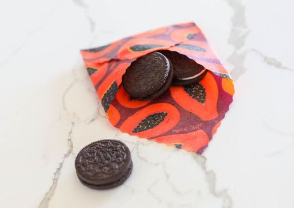 OREO cookies spilling out of a colorful fabric bag on a white surface