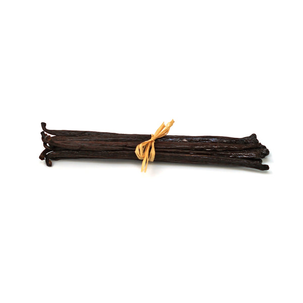 Bunch of vanilla beans tied with a yellow string on a white background