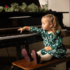 Close-up of snowy pine tree block print and ruffle details on Mon Coeur girls' winter dress