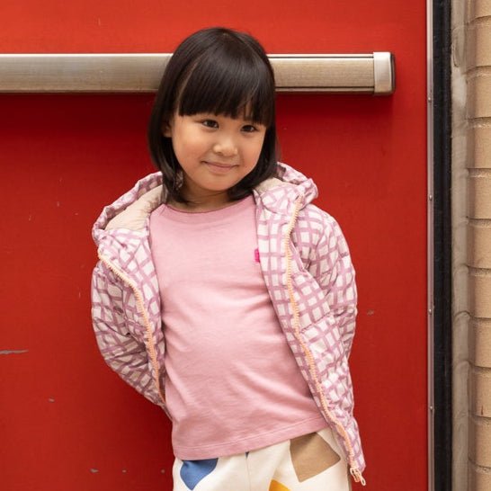 Mon Coeur Pink Grid Puffer jacket laid flat, showing hood and side pockets in soft pink