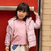 Child wearing the Mon Coeur Pink Grid Puffer jacket outdoors, styled for autumn and back to school