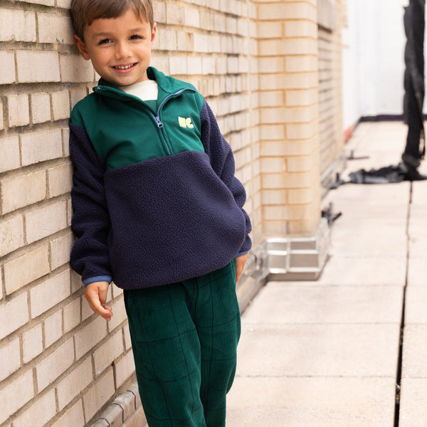 Child wearing Mon Coeur Navy Sherpa Zip Up with half-zip closure, sustainable kids fleece