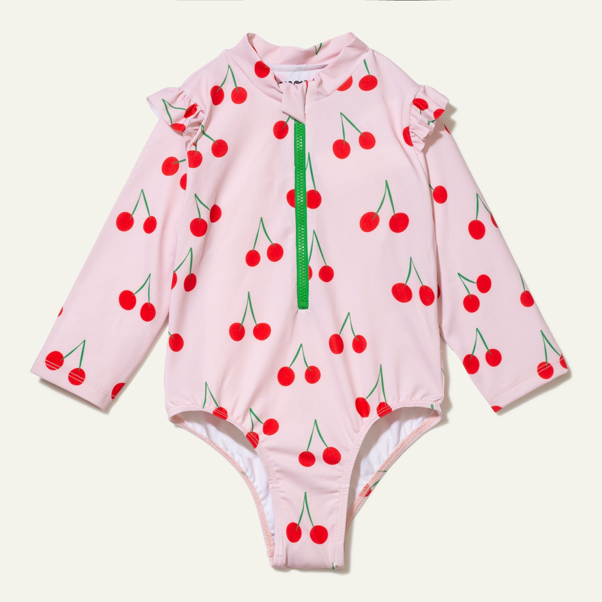 Pink children's swimsuit with cherry pattern on a white background