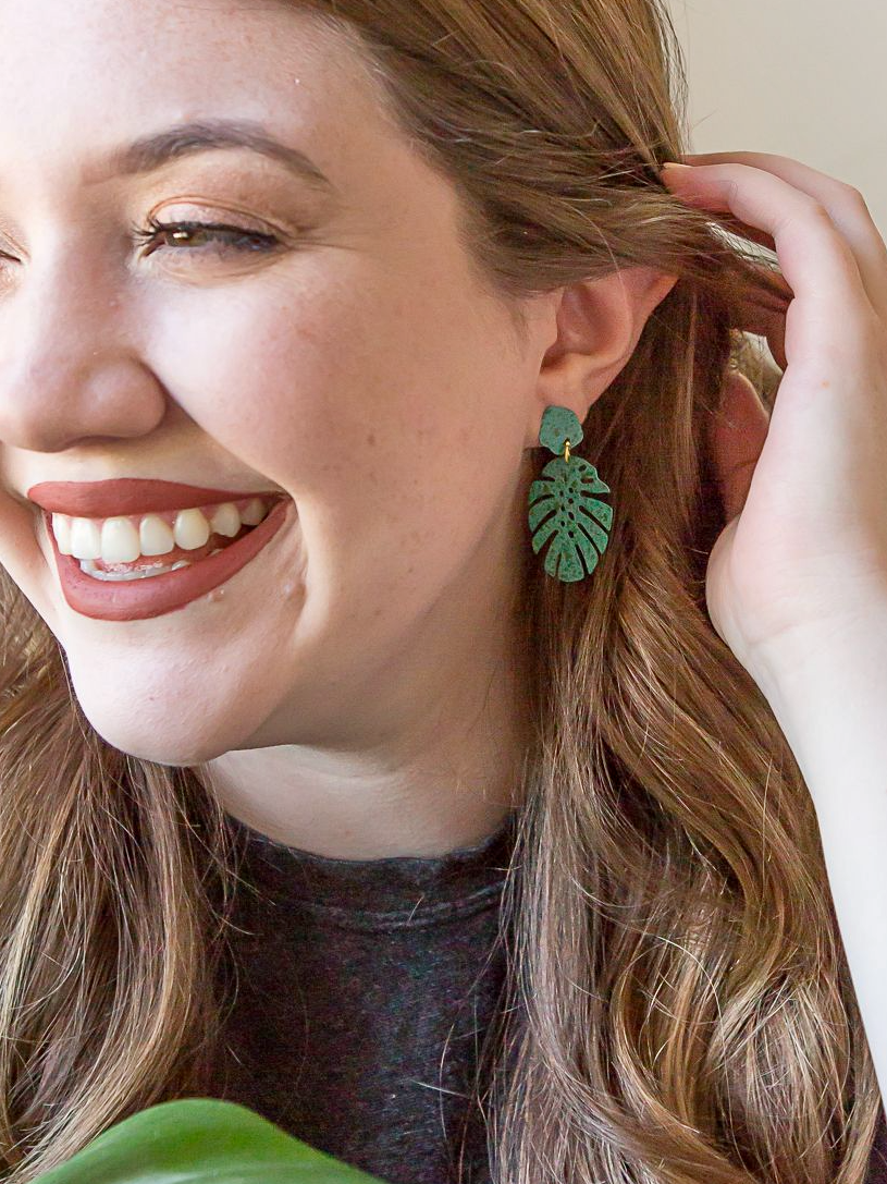 Fair Anita monstera stud earrings in teal hand-painted recycled brass, close-up product view