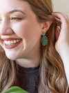 Fair Anita monstera stud earrings in teal hand-painted recycled brass, close-up product view