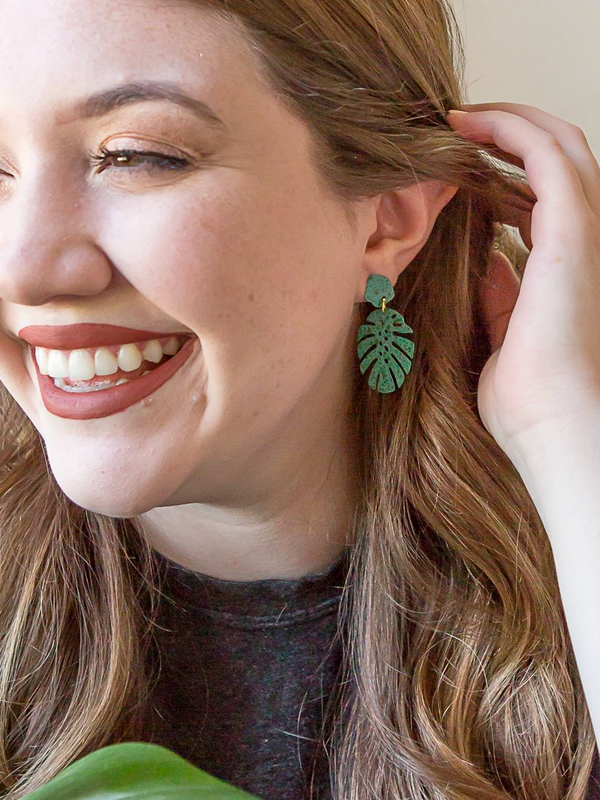 Fair Anita monstera stud earrings in teal hand-painted recycled brass, close-up product view