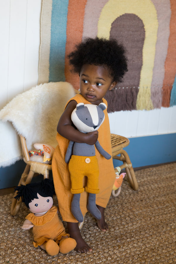 Apple Park mustard muslin sleeveless coverall displayed with Benny Badger and Knit Pal soft toys