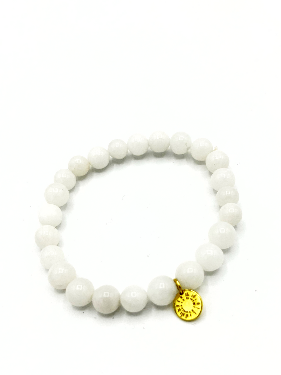 Close-up of white agate stone bracelet with star burst charm detail
