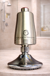 Metallic shower head with 'NaturalAction.com' branding on a bathroom counter.