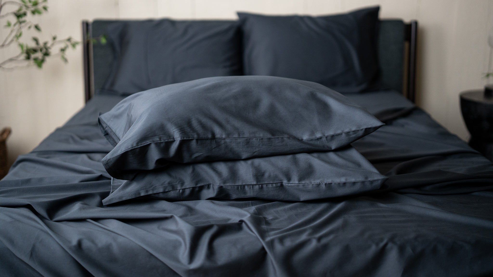 Dark blue bedding set on a bed with pillows and duvet