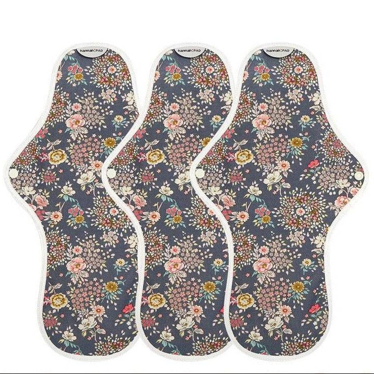 Three floral-patterned sanitary pads on a white background