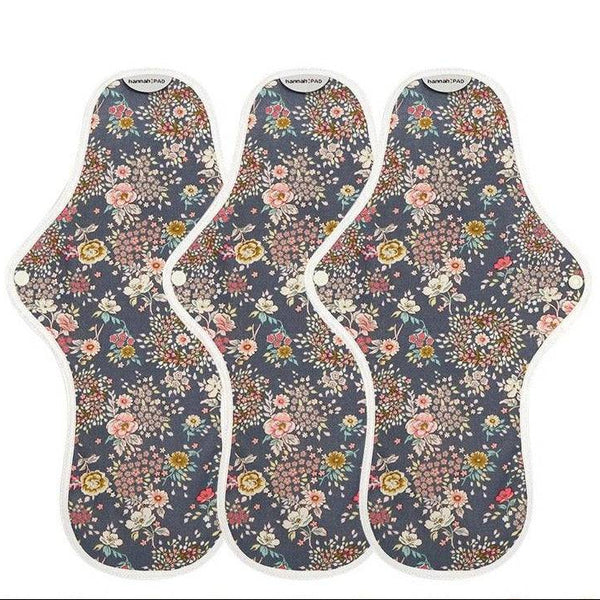 Three floral-patterned sanitary pads on a white background