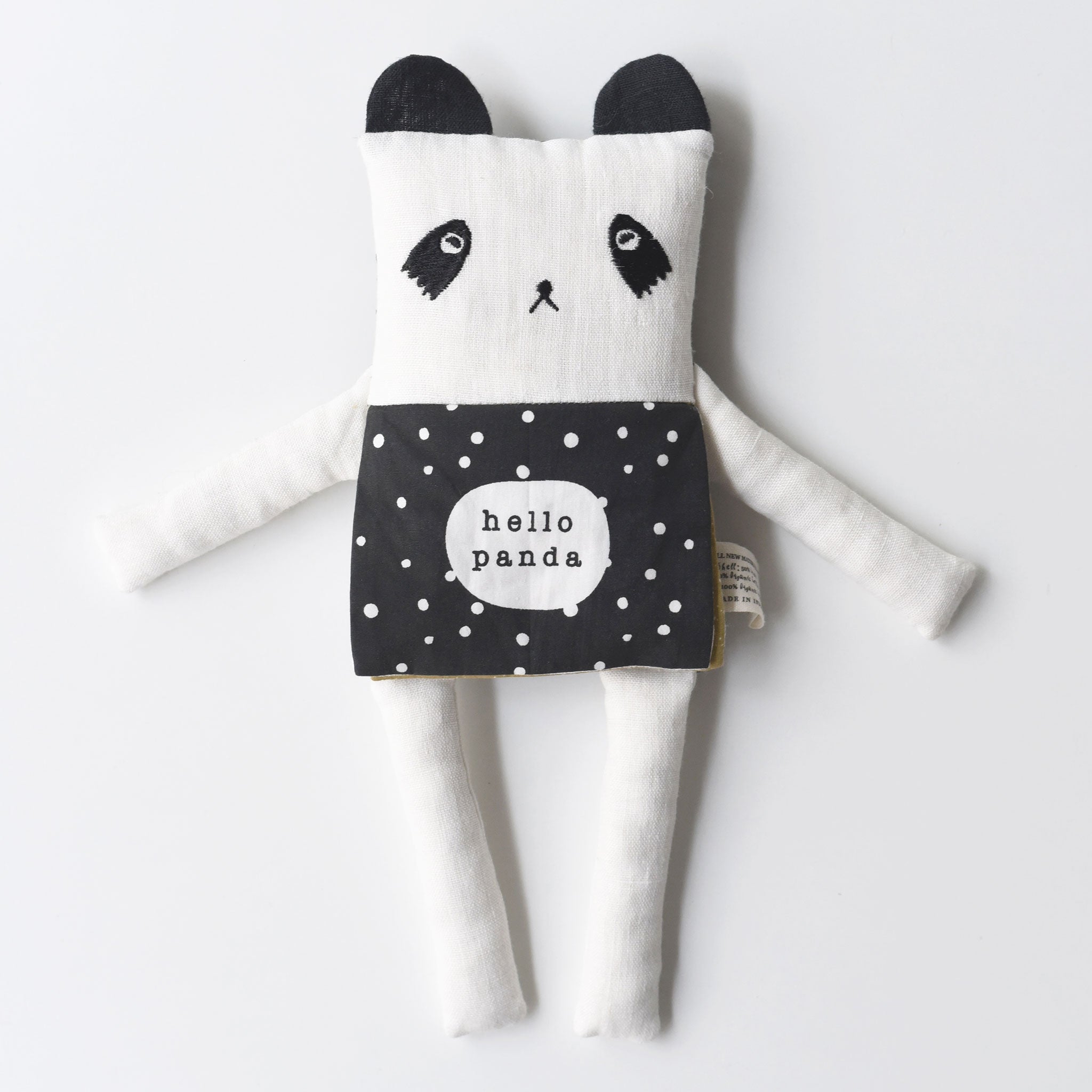 Black and white panda plush toy with a polka dot apron on a light gray background