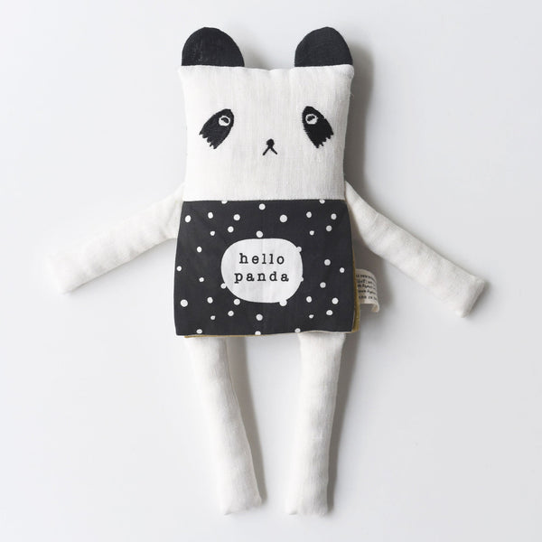 Black and white panda plush toy with a polka dot apron on a light gray background