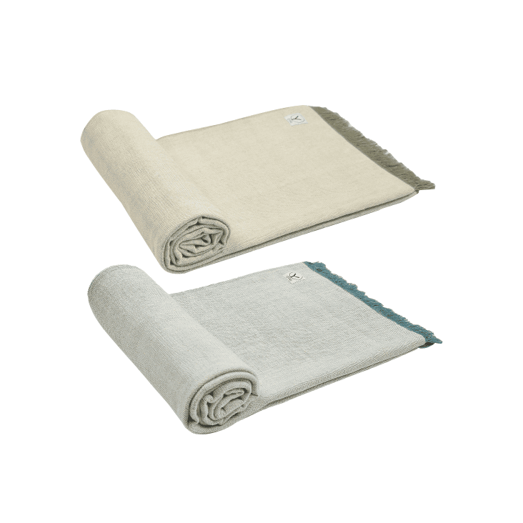 Two folded towels, one beige and one gray, on a white background