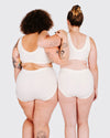 Two people wearing white tank tops and shorts from behind on a plain background