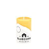 Yellow candle with a Bluecorn Beeswax label on a white background