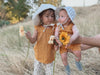 Mustard organic muslin baby coverall styled with pink flower pants and mustard muslin dress