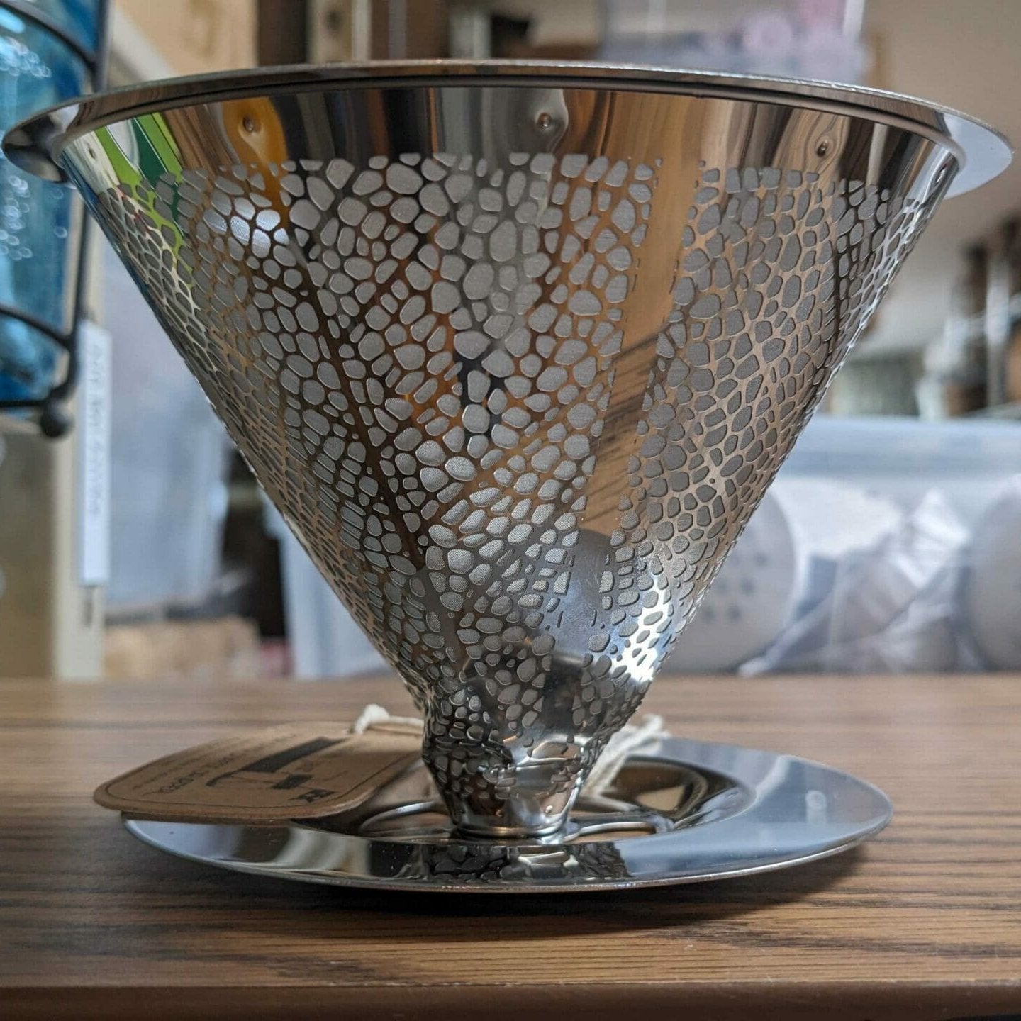 Metallic honeycomb-patterned coffee filter on a wooden surface