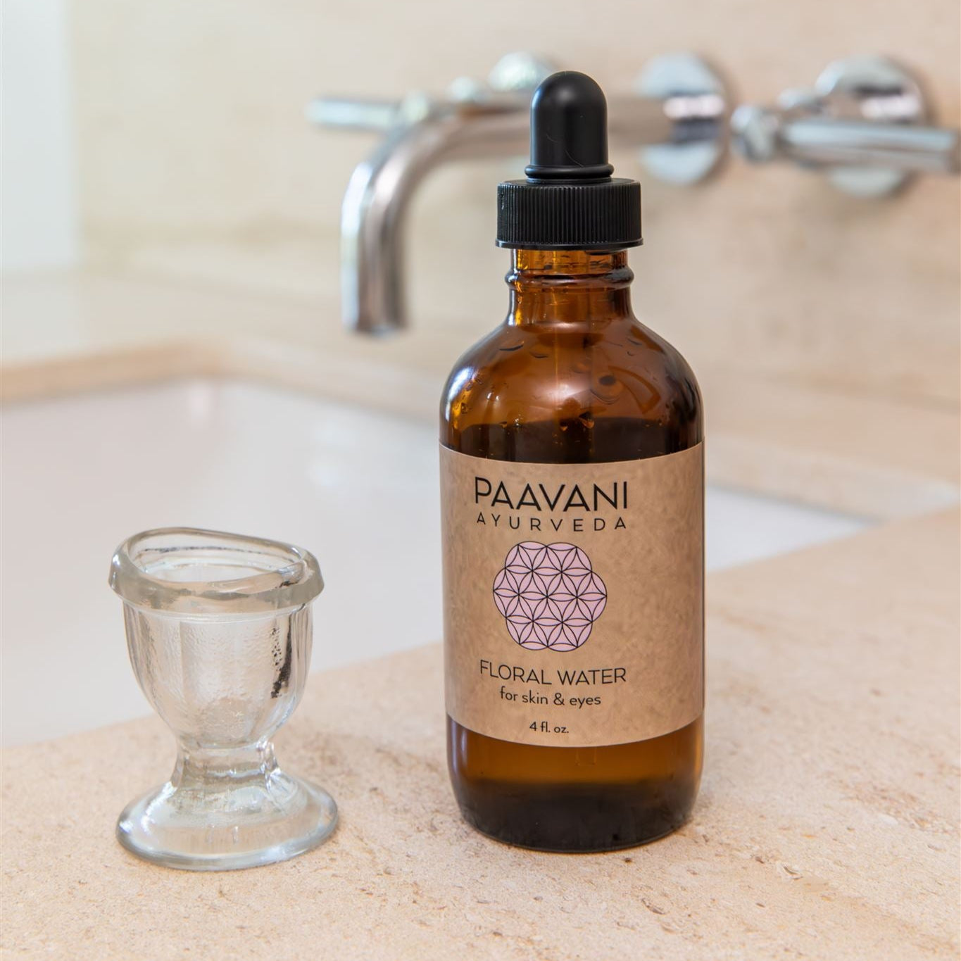 Brown bottle of Paavani Ayurveda floral water with a dropper on a bathroom counter.