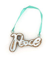 Close-up of handmade peace ornament made from mango wood and reclaimed tin, measuring 3.5 by 2.25 inches