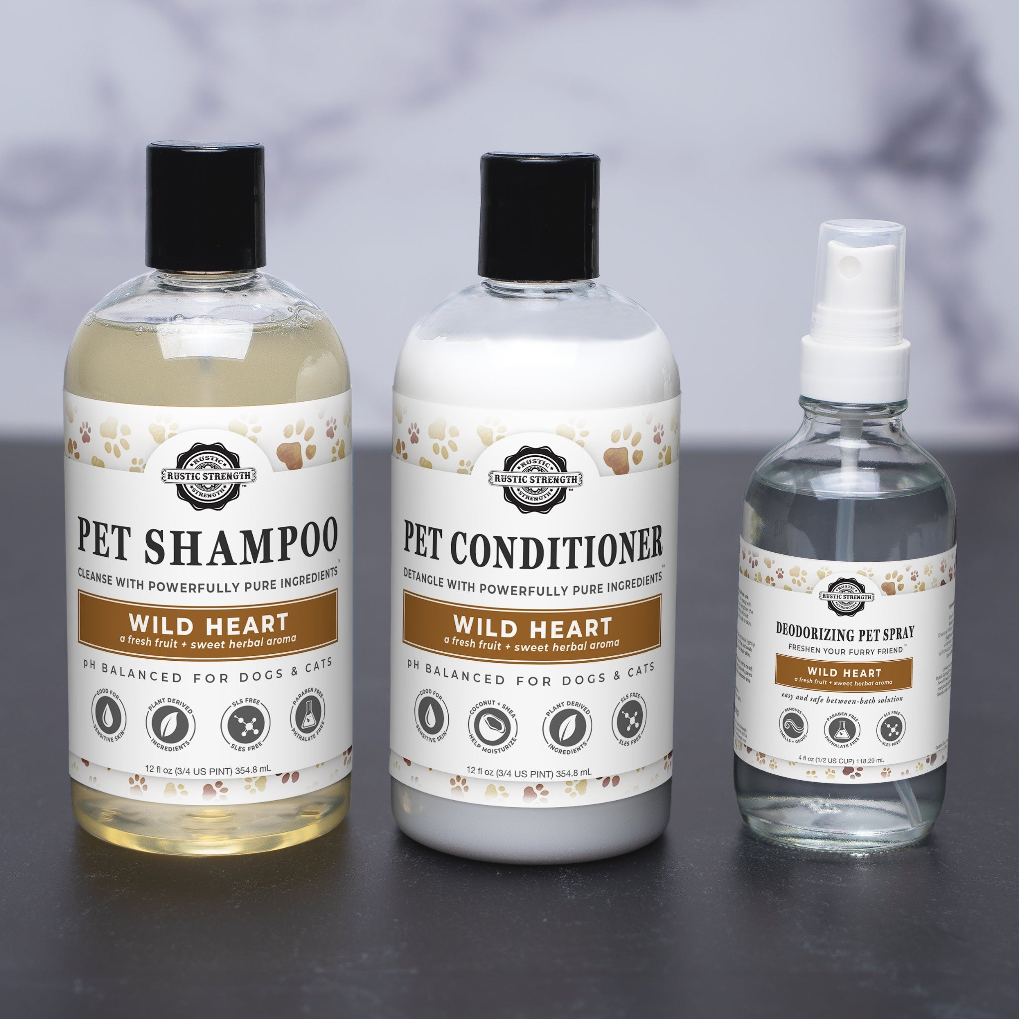 A set of three pet care products from Rustic Strength including a shampoo, conditioner, and deodorizing spray, each in labeled bottles.