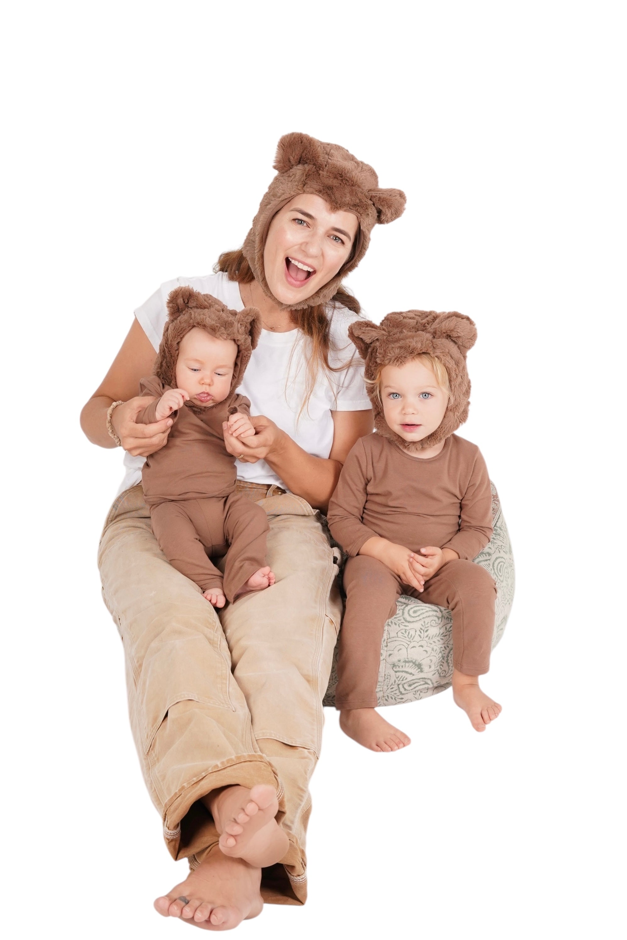 Woman and two children in bear costumes sitting on a white background