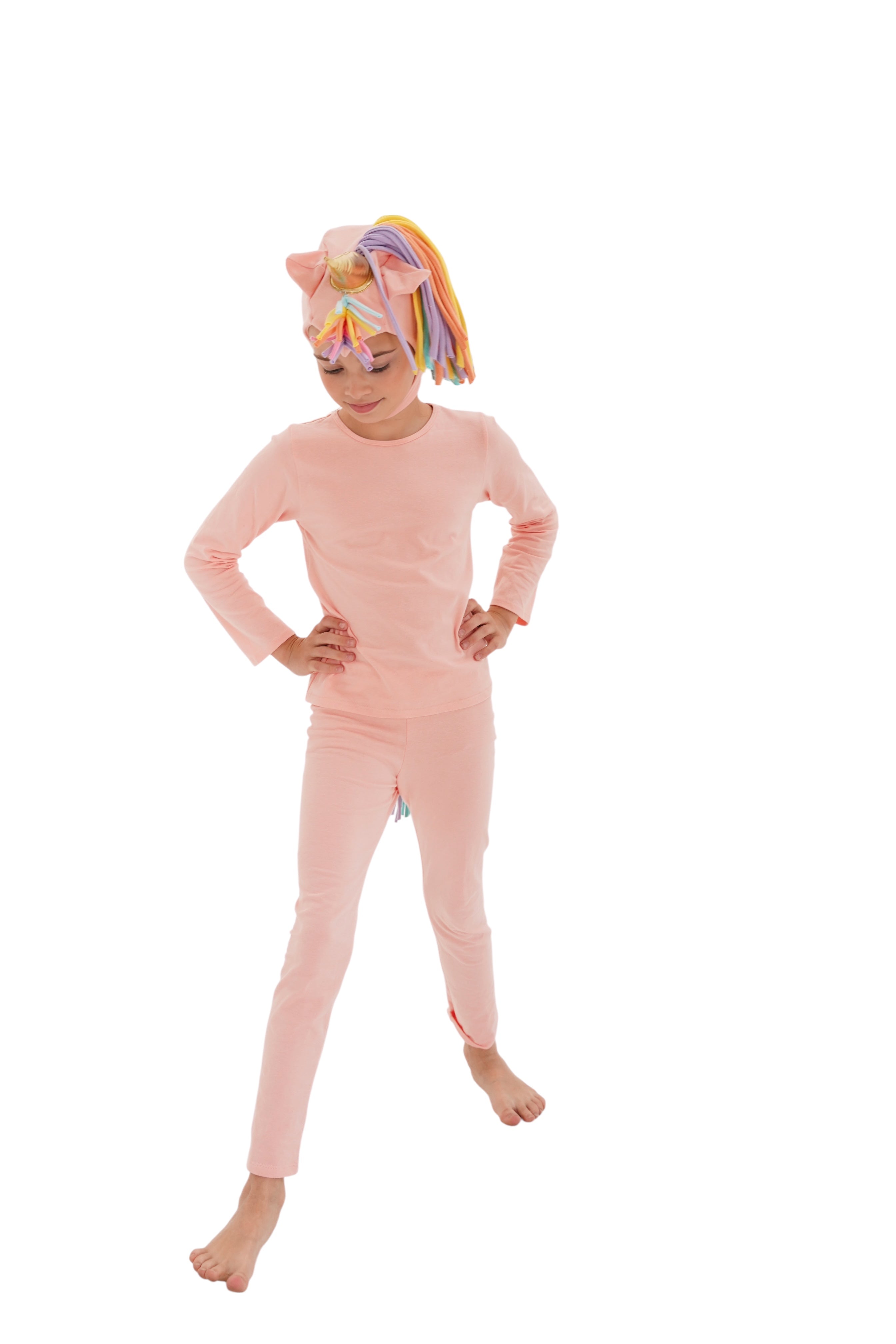 Child wearing a pink onesie with a rainbow unicorn headband on a white background