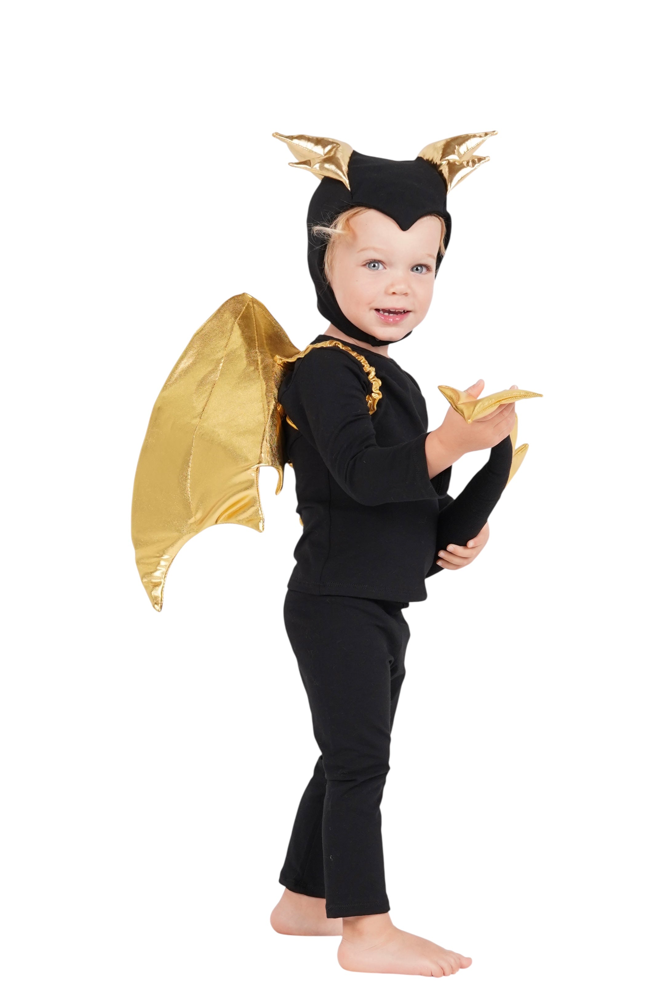 Child wearing a black and gold devil costume with wings on a white background