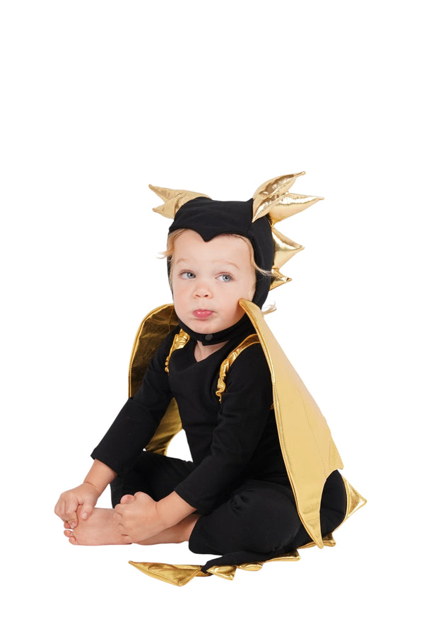 Child wearing a black and gold dragon costume on a white background