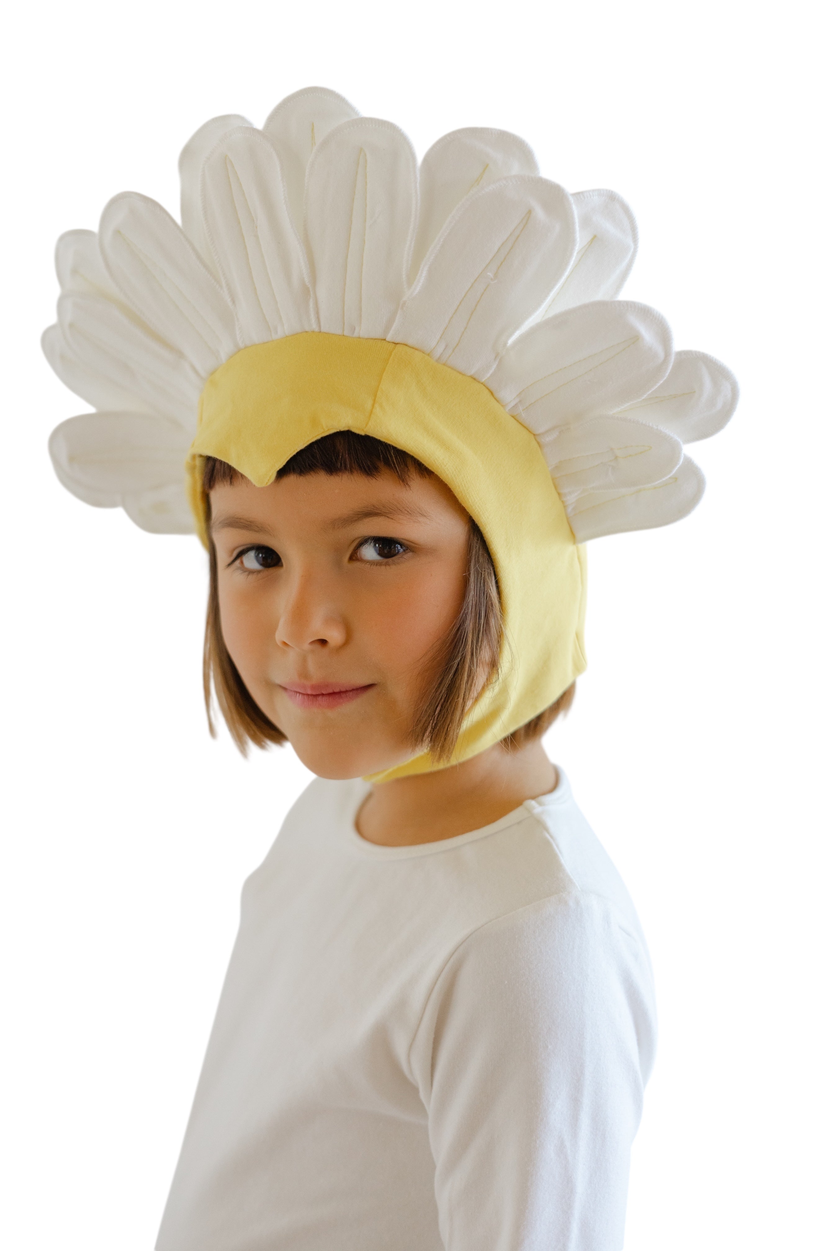 Child wearing a daisy costume with a white flower head and yellow center on a white background