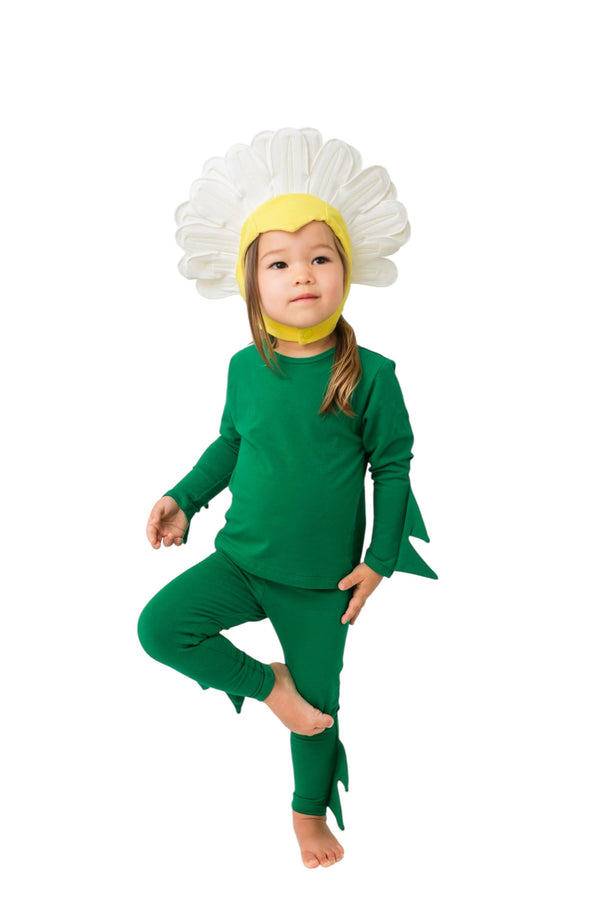 Child in a green flower costume with a white flower head and yellow center on a white background
