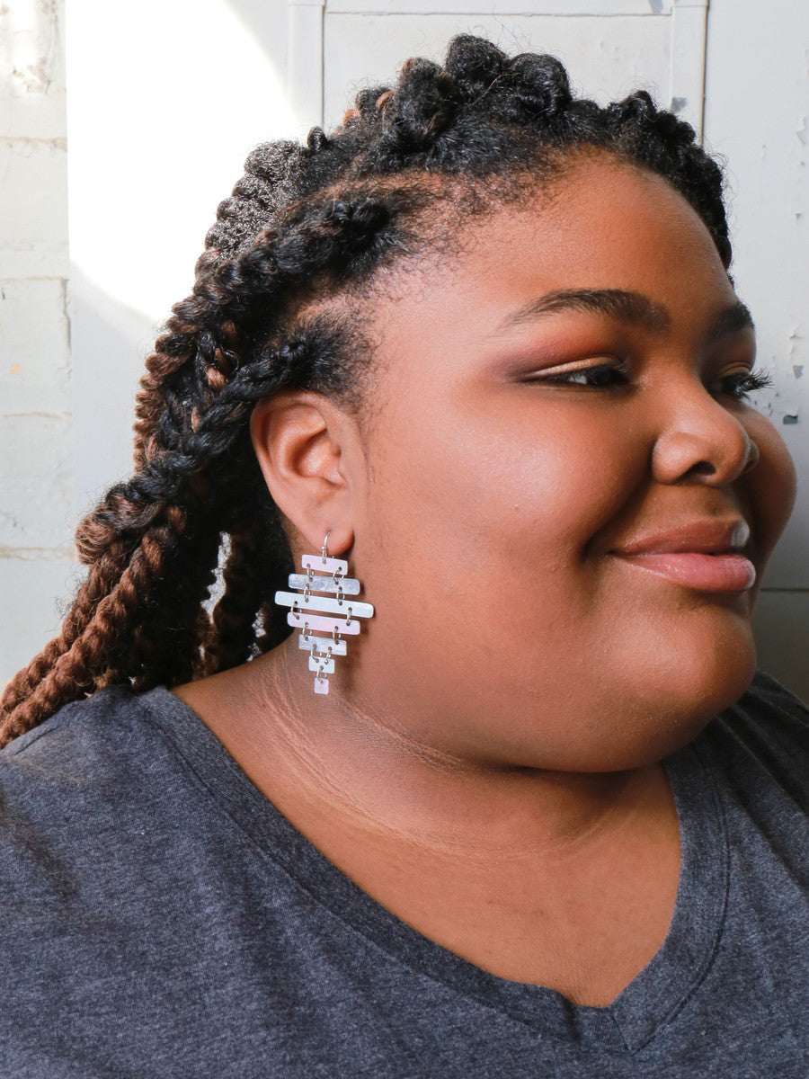 Close-up of pink and silver rustic ladder earrings handcrafted by Fair Anita artisans in India