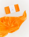 Orange scarf with a matching box on a white background