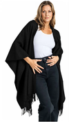 Woman wearing a black fringed poncho over a white top and jeans on a white background