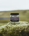 Jar of Arctic Thyme Salt on a mossy rock with a blurred natural background
