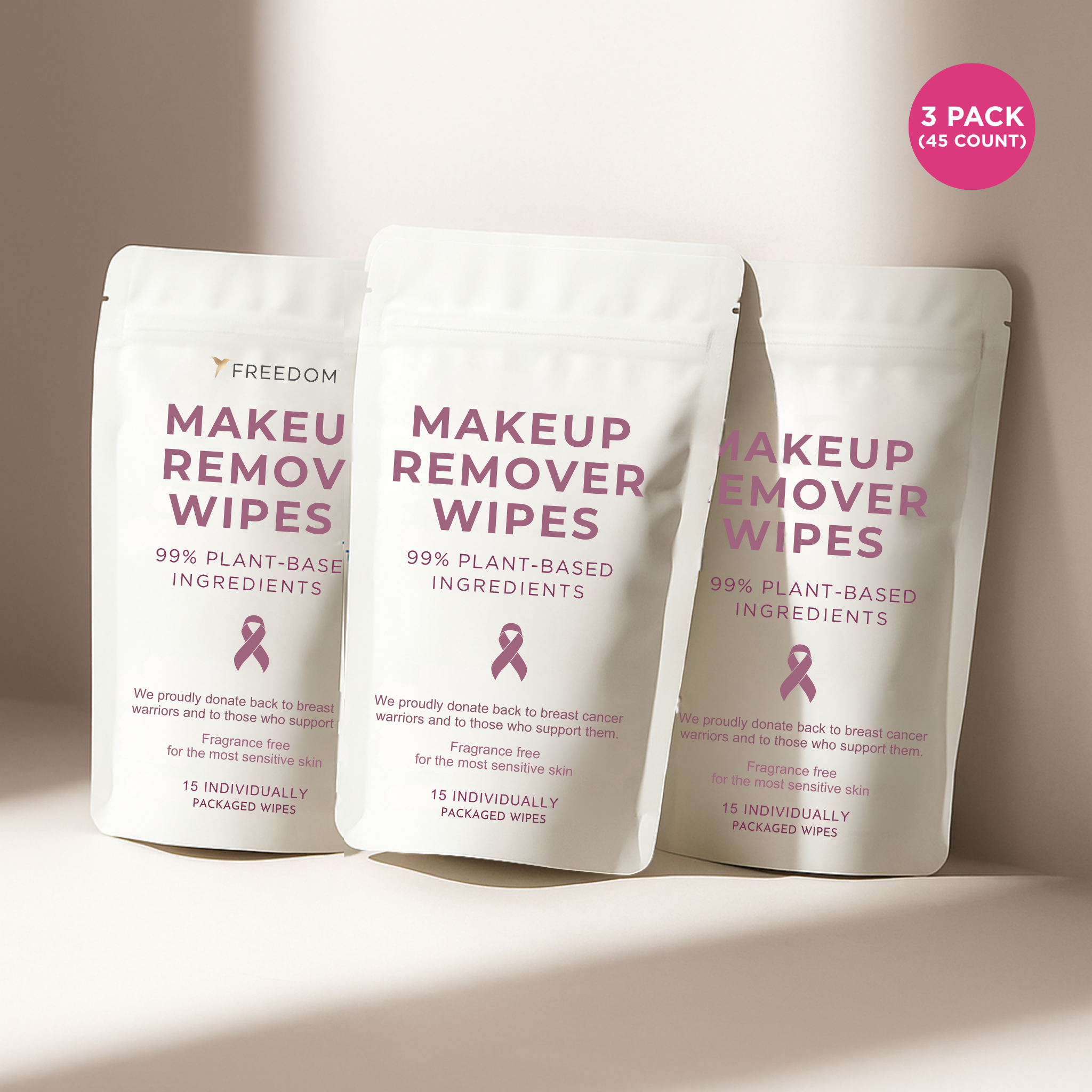 Three packs of Freedom Makeup Remover Wipes with a pink ribbon on a beige background