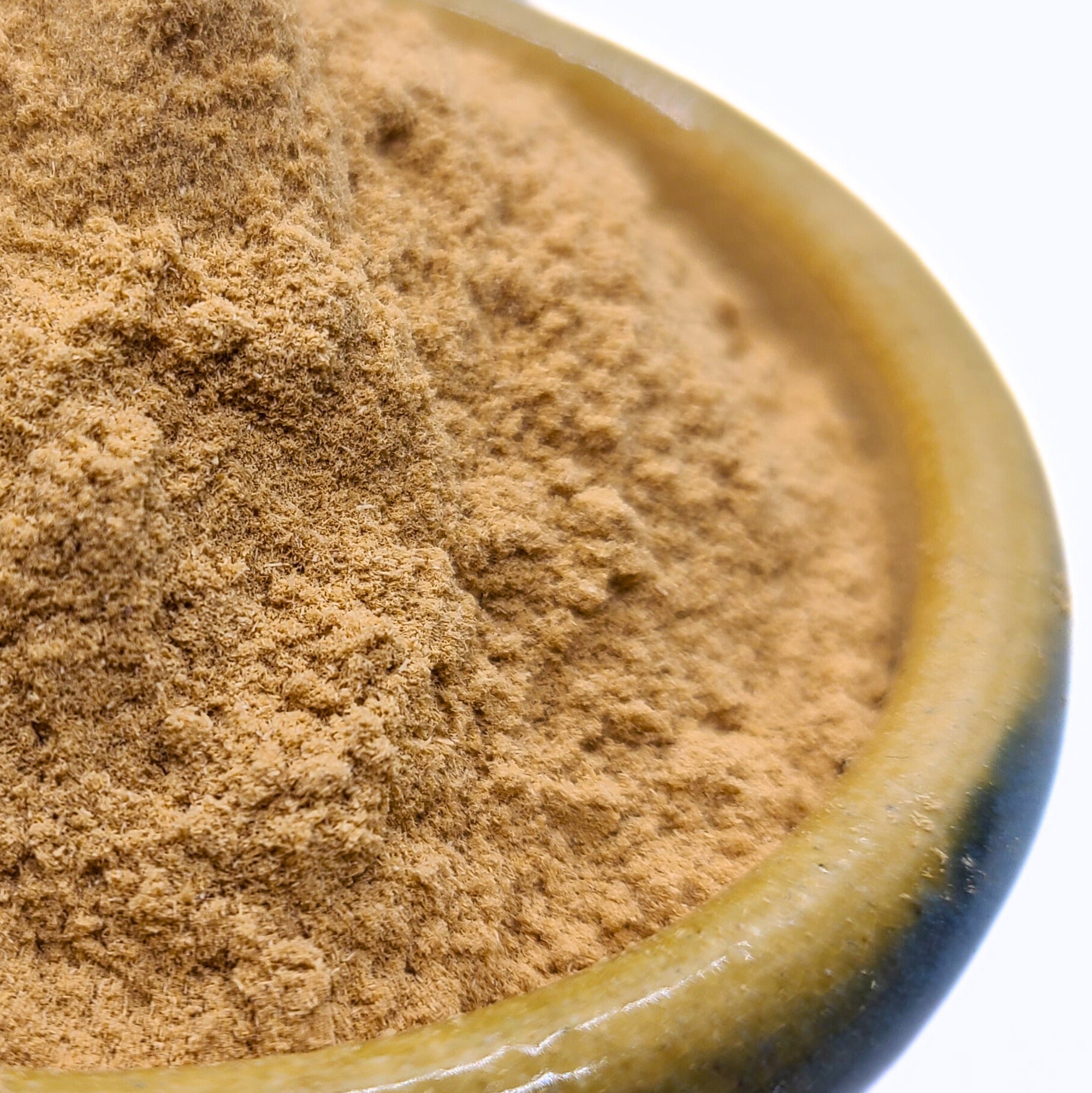 Close-up of brown powder in a ceramic container