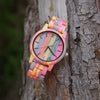 Colorful wooden watch on a tree trunk