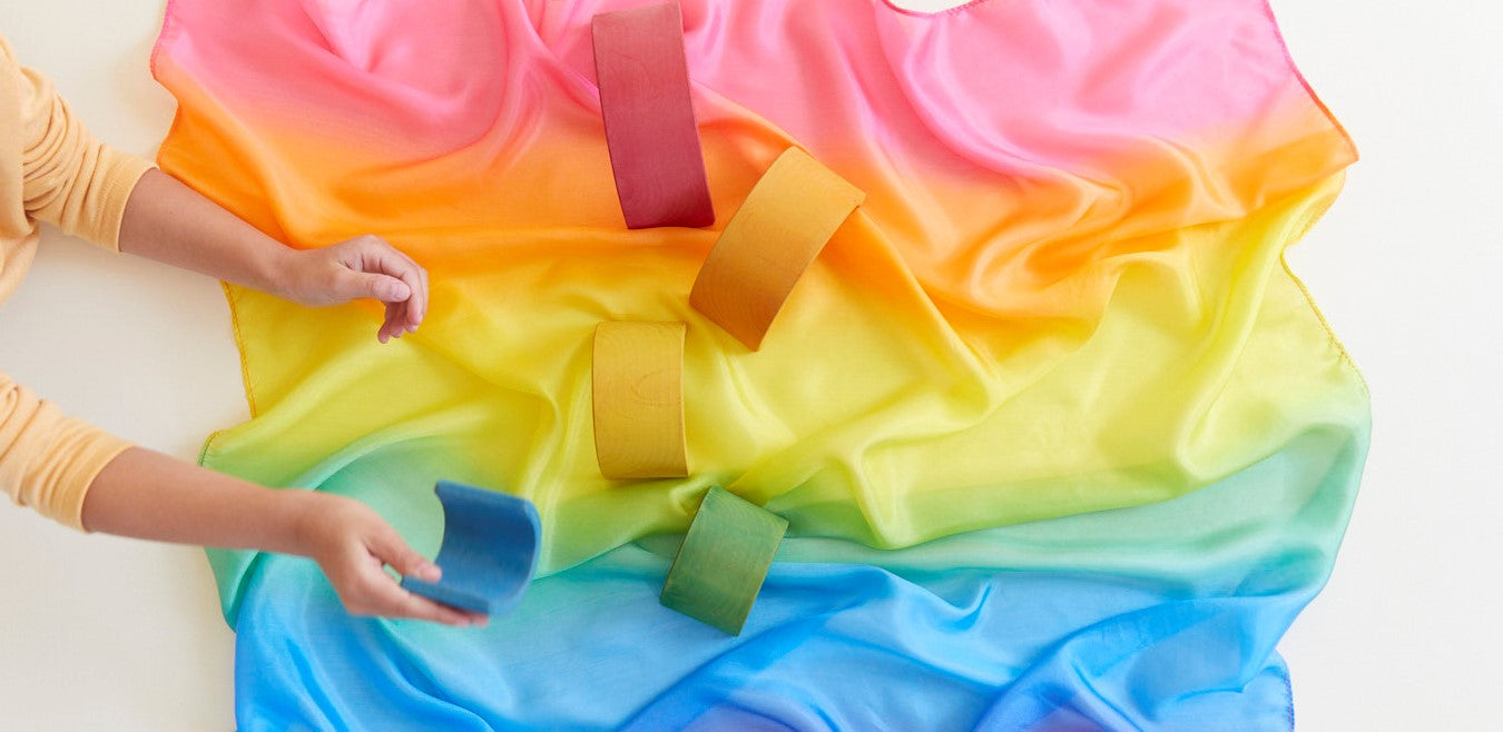Close-up of Sarah's Silks Rainbow Playsilk fabric showing soft silk texture and vivid rainbow hues